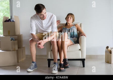 Couple taking break from unpacking in new house Stock Photo