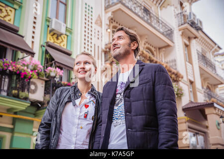 handsome couple tourist staying against the background of colorful houses. Love story. Kyiv Stock Photo