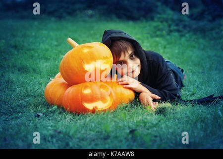 Child in scary costume with pumpkin Stock Photo