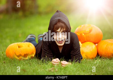 Child in scary costume with pumpkin Stock Photo