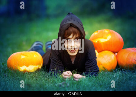 Child in scary costume with pumpkin Stock Photo