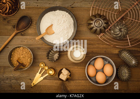 Flatlay collection of tools and ingredients for home baking on a dark wooden table shot from above Stock Photo