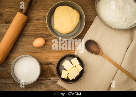 Flatlay collection of tools and ingredients for baking cookies on a dark wooden table. Shot from above Stock Photo