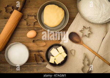 Flatlay collection of tools and ingredients for baking Christmas cookies on a dark wooden table. Shot from above Stock Photo