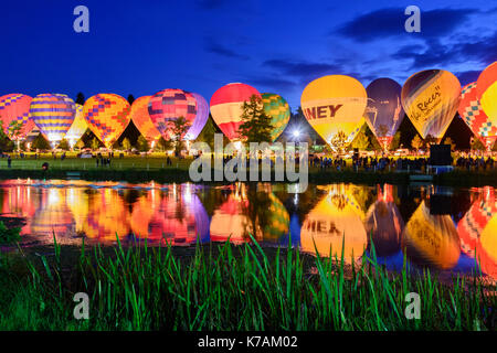 Longleat, Wiltshire, UK. 14th September 2017. A row of illuminated hot air balloons are reflected in the lake at Longleat's Sky Safari Night Glow. The Sky Safari takes place at Longleat Safari Park, Wiltshire on 15th - 17th September 2017. The preview took place yesterday (Thursday) night. Credit: Alison Eckett / Alamy Live News. Stock Photo