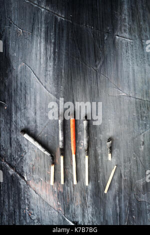 Used matches in a row against a dark grunge background. Stock Photo