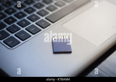 SD memory card on top of computer. Stock Photo