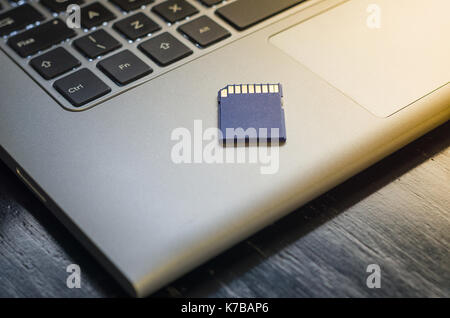 SD memory card on top of computer. Stock Photo