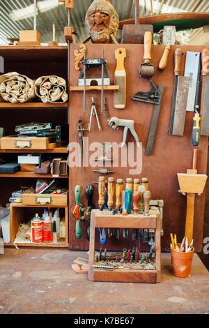 Various equipment hanging on wall at workshop Stock Photo