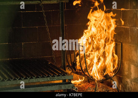 Fire burning beside grill in fireplace Stock Photo