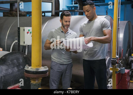 Men working in industrial setting Stock Photo