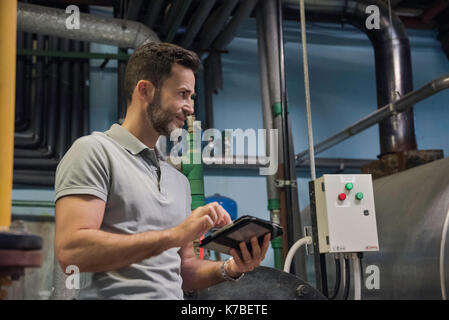 Man using digital tablet in industrial setting Stock Photo