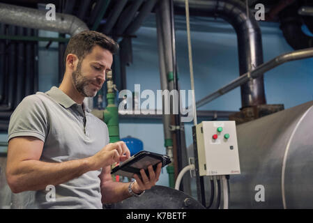 Man using digital tablet in industrial setting Stock Photo