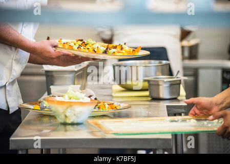 Chefs preparing food in commercial kitchen Stock Photo