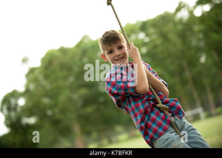 Boy swinging on rope Stock Photo