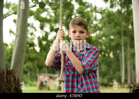 Boy on rope swing, portrait Stock Photo