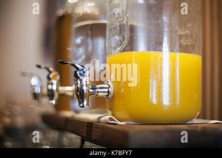 Orange juice in glass dispenser Stock Photo