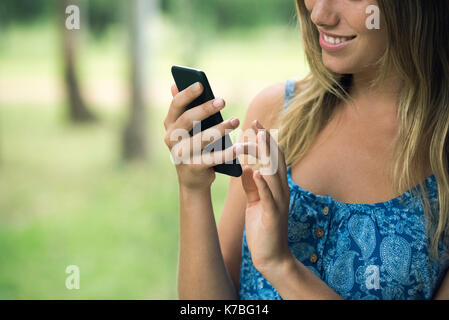 Young woman using smartphone, cropped Stock Photo