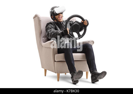 Biker seated in an armchair using a VR headset and holding a steering wheel isolated on white background Stock Photo
