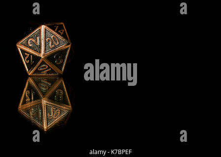 A twenty sided  polyhedral die on a mirrored surface. These type of dice are used for role playing games such as Dungeons & Dragons. Stock Photo