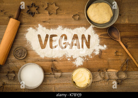 Flatlay collection of tools and ingredients for baking vegan Christmas cookies with margarine and chia seeds as egg replacement and the word vegan wri Stock Photo