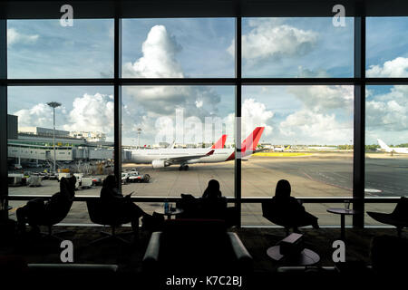Silhouette of passenger waiting flight for travel in lounge at airport terminal. Interior airport. Stock Photo