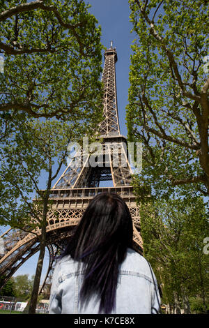 A woman standing in front of the Eiffel Tower in Paris, France. Stock Photo