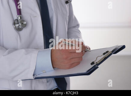 Male doctor standing with folder, isolated on white background Stock Photo