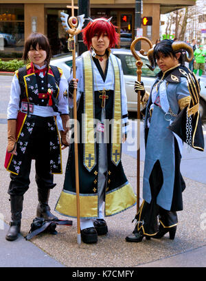 SEATTLE - APRIL 6, 2012: Young women wearing elaborate costumes pose on the sidewalk outside the 15th annual Sakura-Con anime convention.