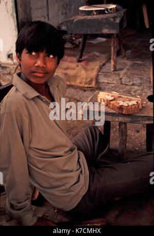 iNDIAN BOY CARVING A WOOD BLOCK Stock Photo