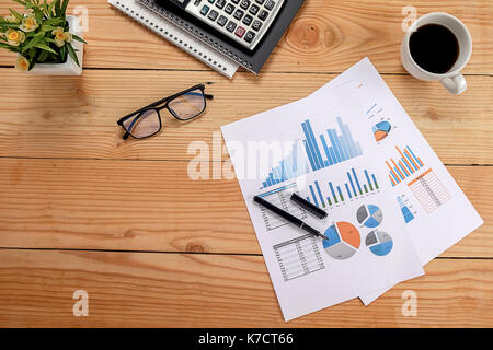 Office desk table with keyboard, notebook, pen, cup of coffee and flower. Top view with copy space (selective focus) Stock Photo