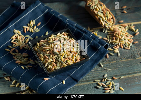 Dry Organic Tricolor Orzo Pasta in a Bowl Stock Photo