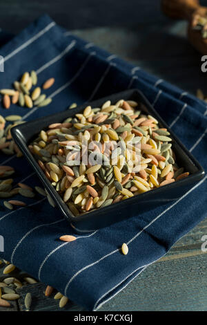 Dry Organic Tricolor Orzo Pasta in a Bowl Stock Photo