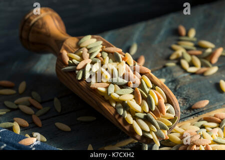 Dry Organic Tricolor Orzo Pasta in a Bowl Stock Photo