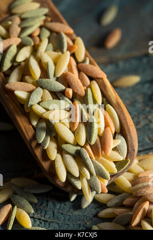 Dry Organic Tricolor Orzo Pasta in a Bowl Stock Photo