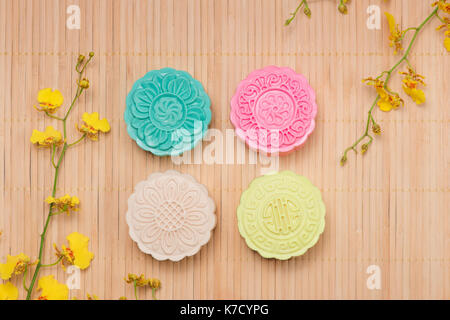 Sweet color of snow skin mooncake. Traditional mid autumn festival foods with tea on table setting. Stock Photo