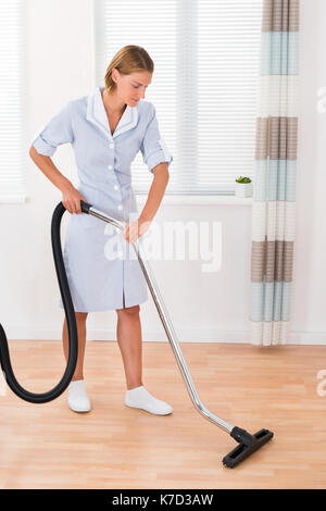 Beautiful Female Maid Cleaning Wooden Floor With Vacuum Cleaner Stock ...