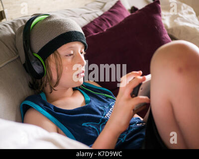 High angle view of boy using smart phone while listening music at home Stock Photo