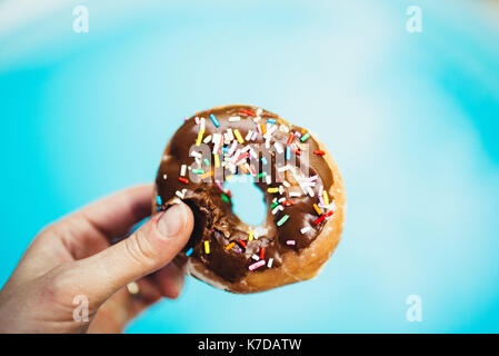 Cropped hand of person holding donut Stock Photo