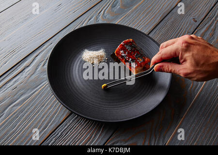 Grilled smoked eel with green apple and citrus chef hand preparing Stock Photo