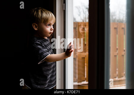 Side view of thoughtful boy looking through window Stock Photo