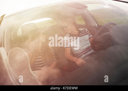 Couple talking while sitting in car seen through windshield Stock Photo