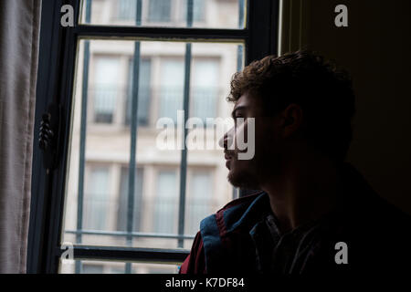 Close-up of thoughtful man looking through window Stock Photo