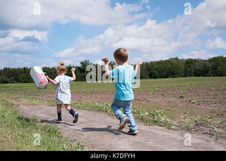 Rear view of a girl with her brother walking on the street Stock Photo ...