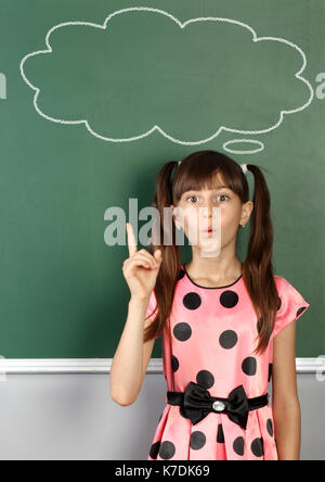 surprised child near empty speech bubble on school blackboard Stock Photo