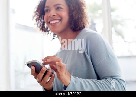 Mid adult woman using cell phone. Stock Photo