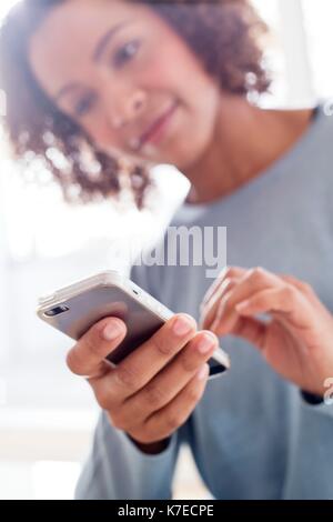 Mid adult woman using cell phone. Stock Photo