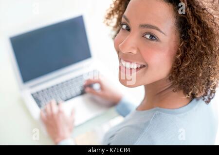 Mid adult woman using laptop. Stock Photo