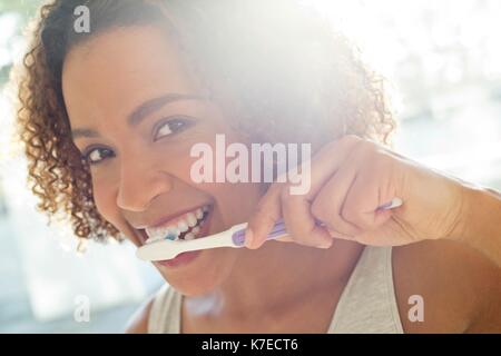 Portrait of mid adult woman brushing teeth. Stock Photo