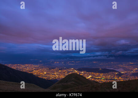 Aerial cityscape of Quito city at night after sunset with a long exposure as seen from the Pichincha volcano, Ecuador. Stock Photo